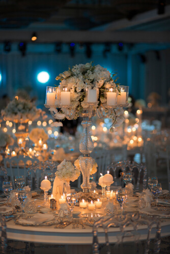 close up of a white, candle-lit wedding table set-up