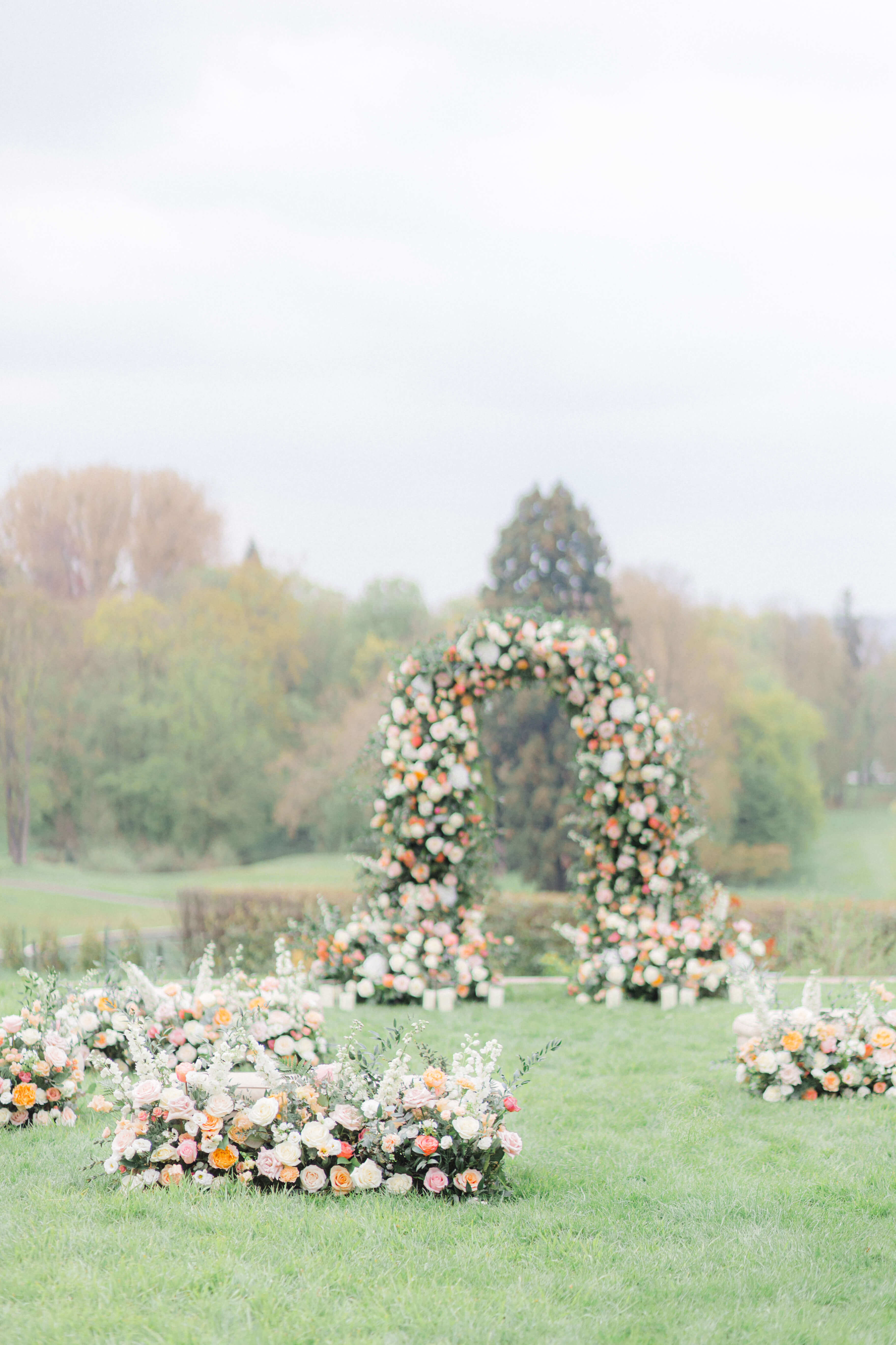 Pastel Floral arch and meadows in an S shape on a lawn in front of Chateau Bouffemont