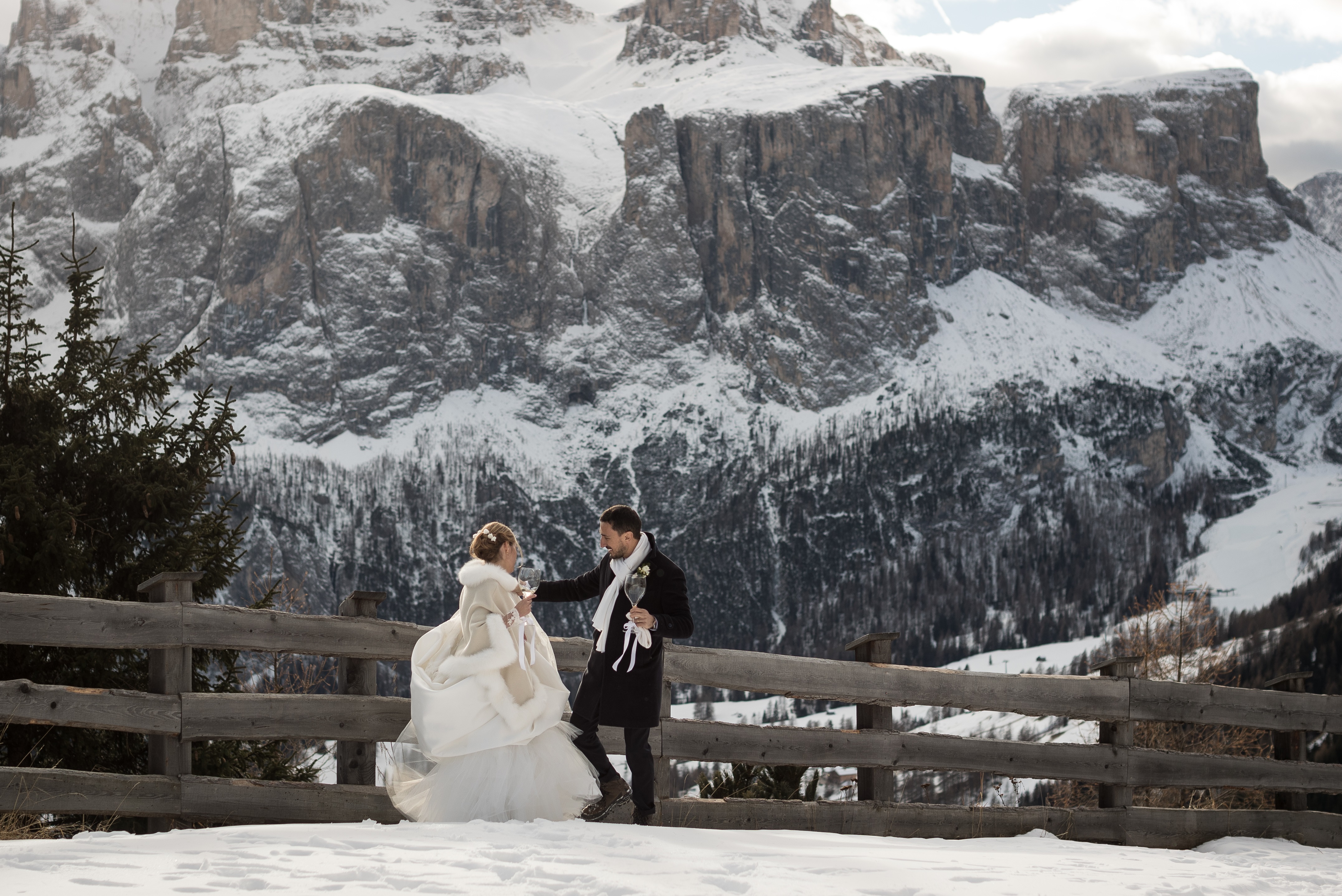 bride and groom toasting  in snow mountains