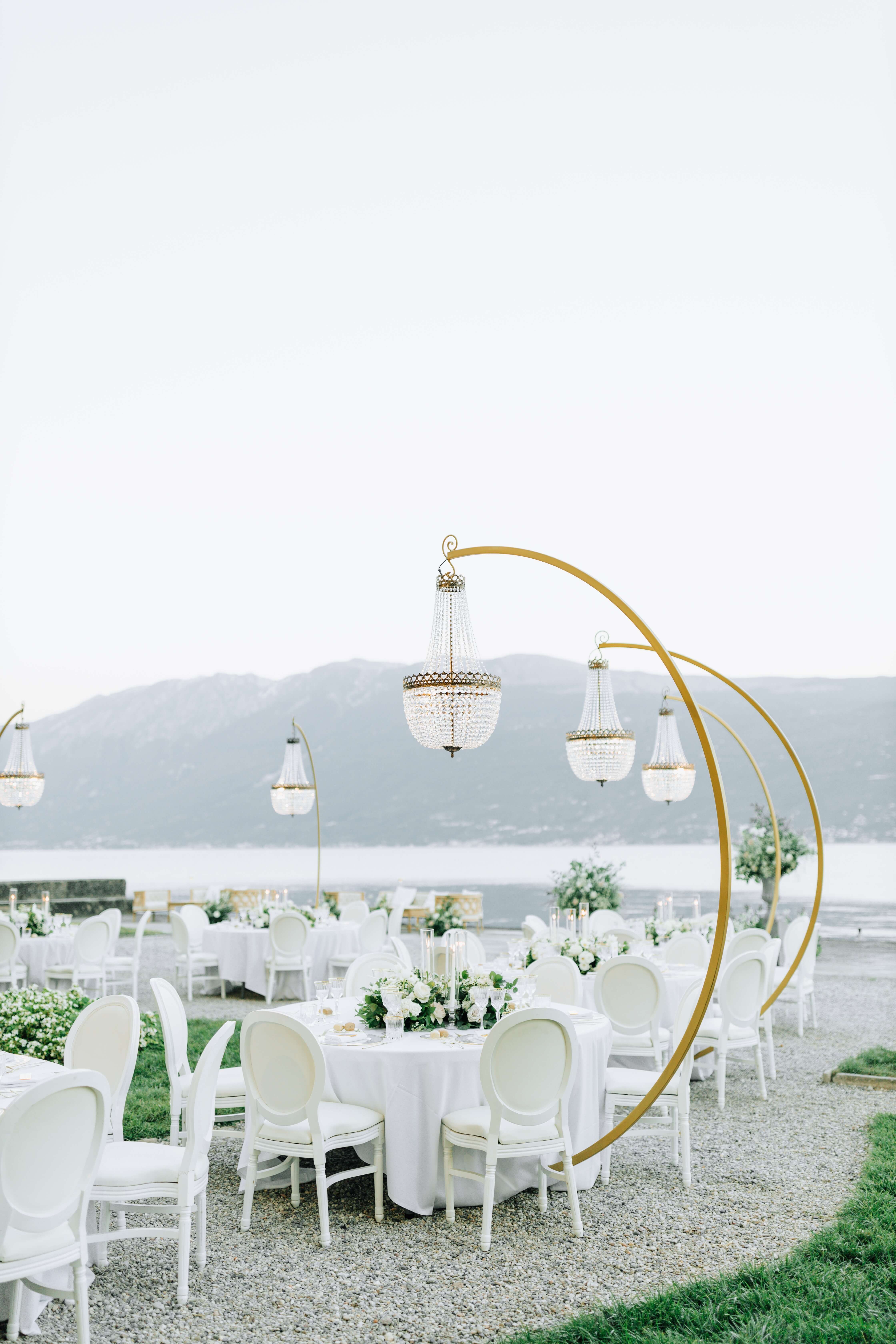 Garden white wedding reception decor on the shores of lake como with crved standchandeliers