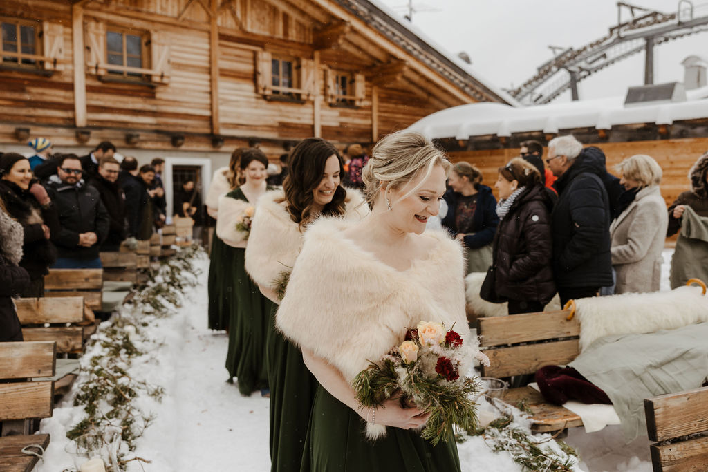 bridesmaids walking down the aisle on the snow at winter ceremony outdoors 