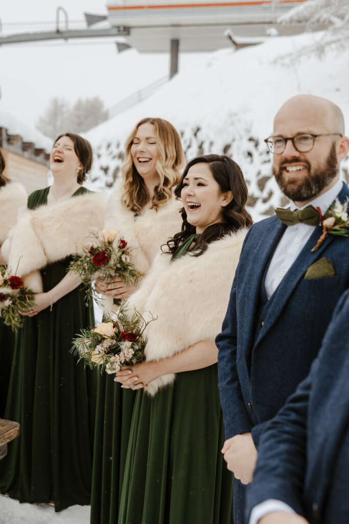 bridesmaids and ushers by ceremony spot  on the snow at winter ceremony outdoors 