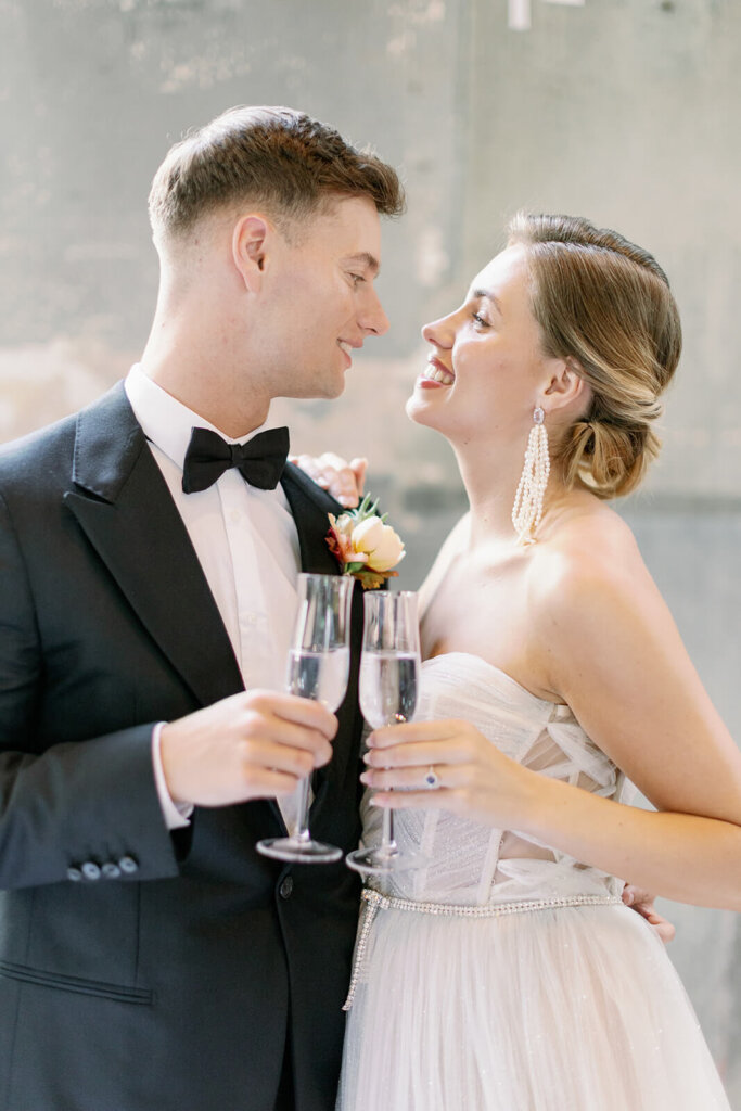 portrait of  newly wed couple toasting with flutes looking into each other eyes