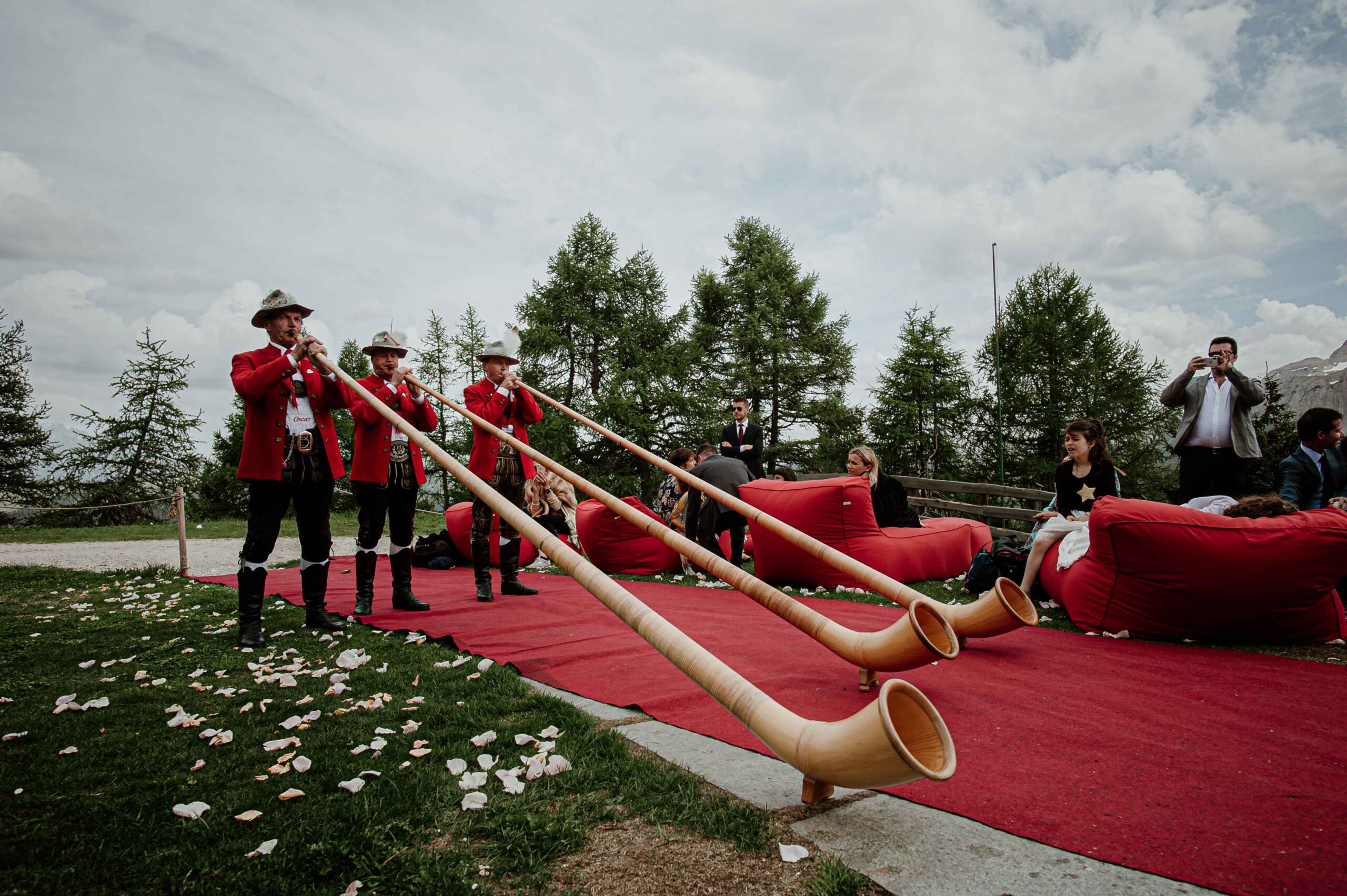 brass long horn trumpet players in red and black unifrom on winter wedding 