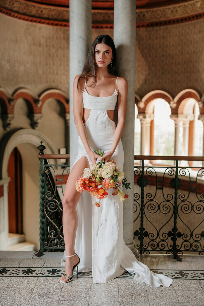 Lake Como wedding planner Villa cipressi internal staircase brdal portrait holding bouquet standing against columns