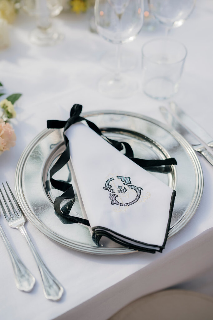 Villa Cipressi - Lake Como wedding planner- bespoke black and white embroidered napkin, with initials in black and champagne gold and balck ribbon bow
